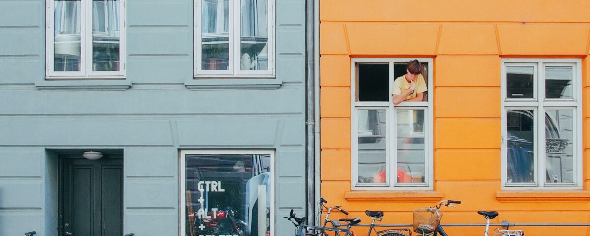 person on window looking at bicycles during daytime