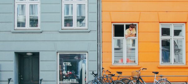 person on window looking at bicycles during daytime